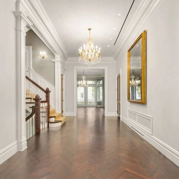 White PVC crown moulding installed at wall-ceiling junction in a living room interior showing clean profile lines integrated with door casing and baseboard trim for unified architectural appearance White PVC crown moulding installed at wall-ceiling junction in a living room interior showing clean profile lines integrated with door casing and baseboard trim for unified architectural appearance
