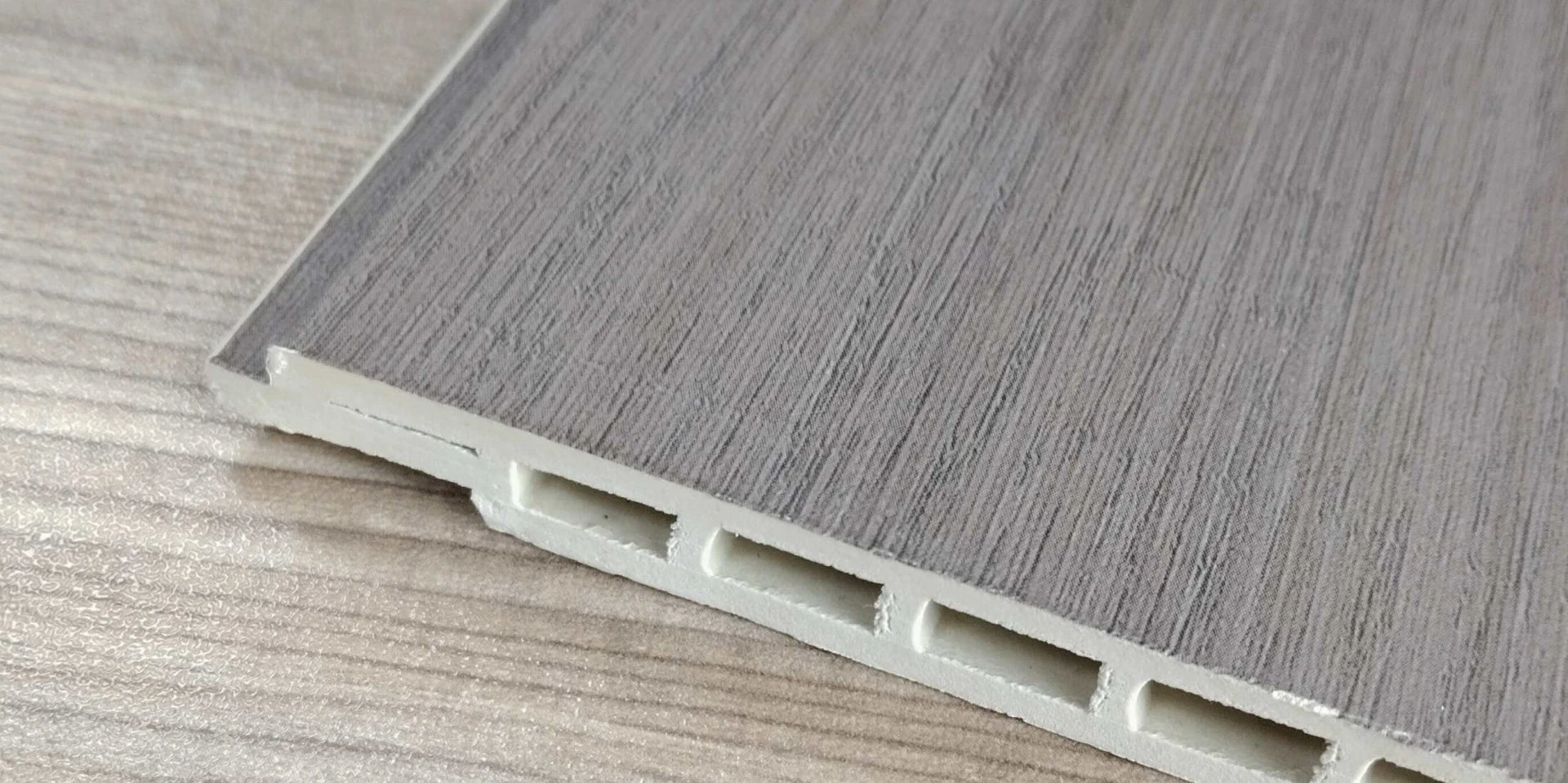 Cross-section of a standard PVC ceiling board. The hollow-chamber construction reduces weight without sacrificing rigidity. The tongue-and-groove edges lock adjacent boards together and conceal the mechanical fasteners behind the visible face. Cross-section of a standard PVC ceiling board. The hollow-chamber construction reduces weight without sacrificing rigidity. The tongue-and-groove edges lock adjacent boards together and conceal the mechanical fasteners behind the visible face.